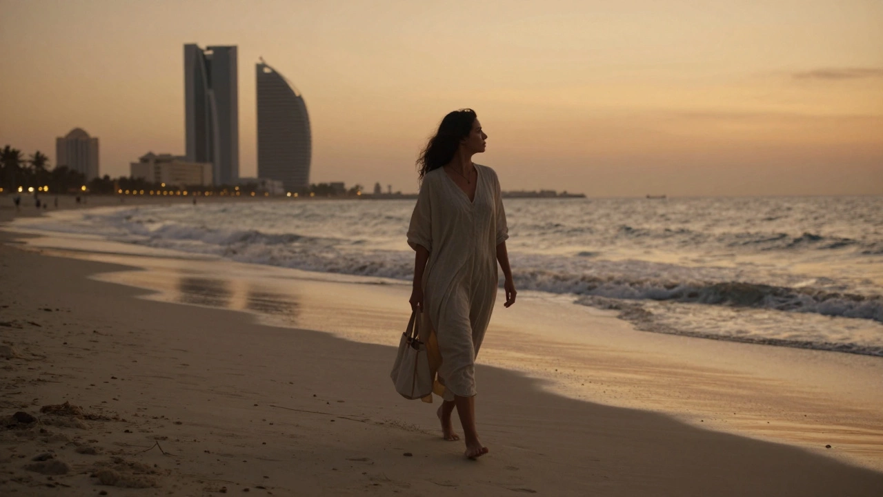 A companion walking alone along Jumeirah Beach at sunset, dressed lightly, gazing at the horizon.